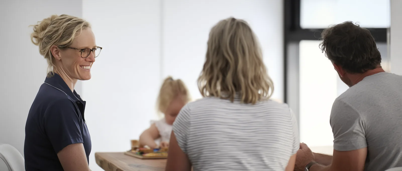 A practitioner sitting with a family in a calm consultation room.